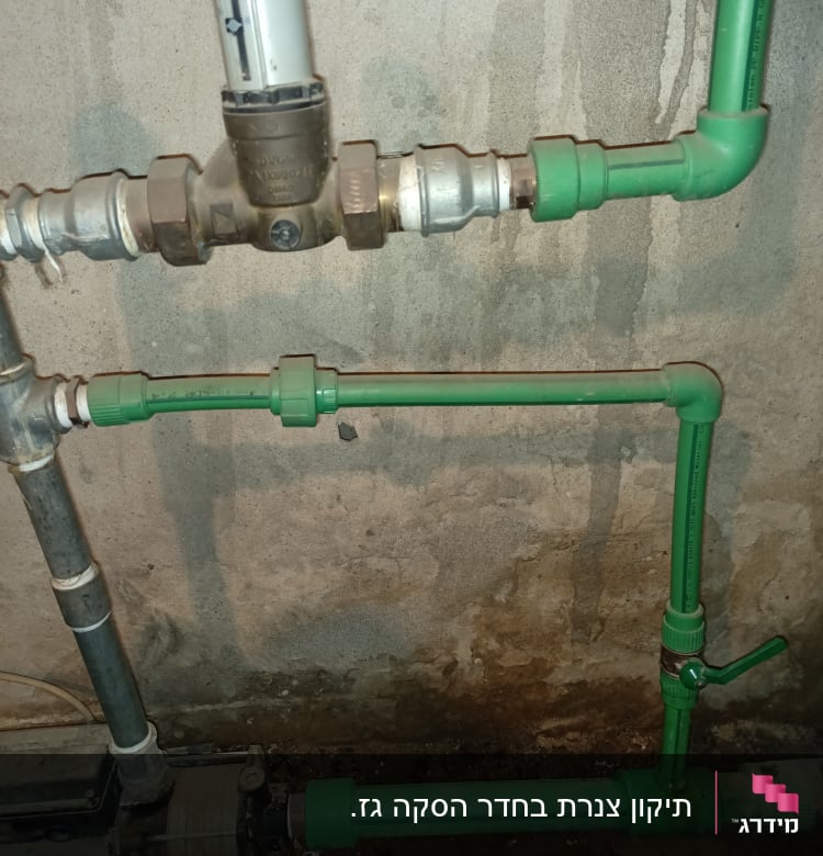 צנרת ירוקה עם שסתום וברז על קיר בטון